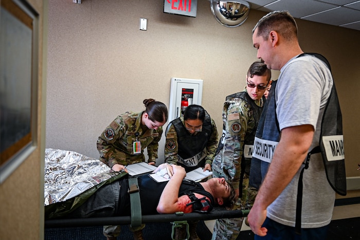 Military members transport a patient by litter carry to simulate a Medical exercise.