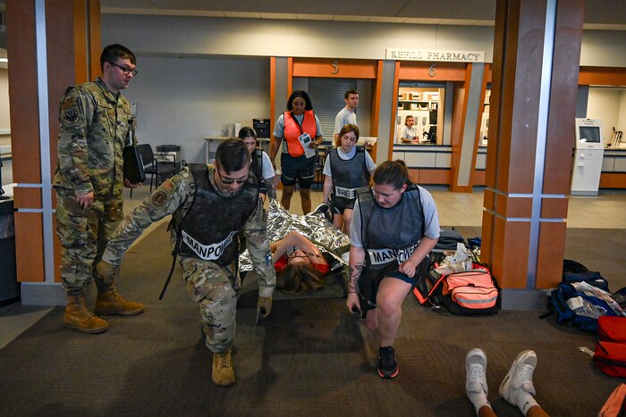 Four military members transport a patient by litter carry to simulate a Medical exercise.