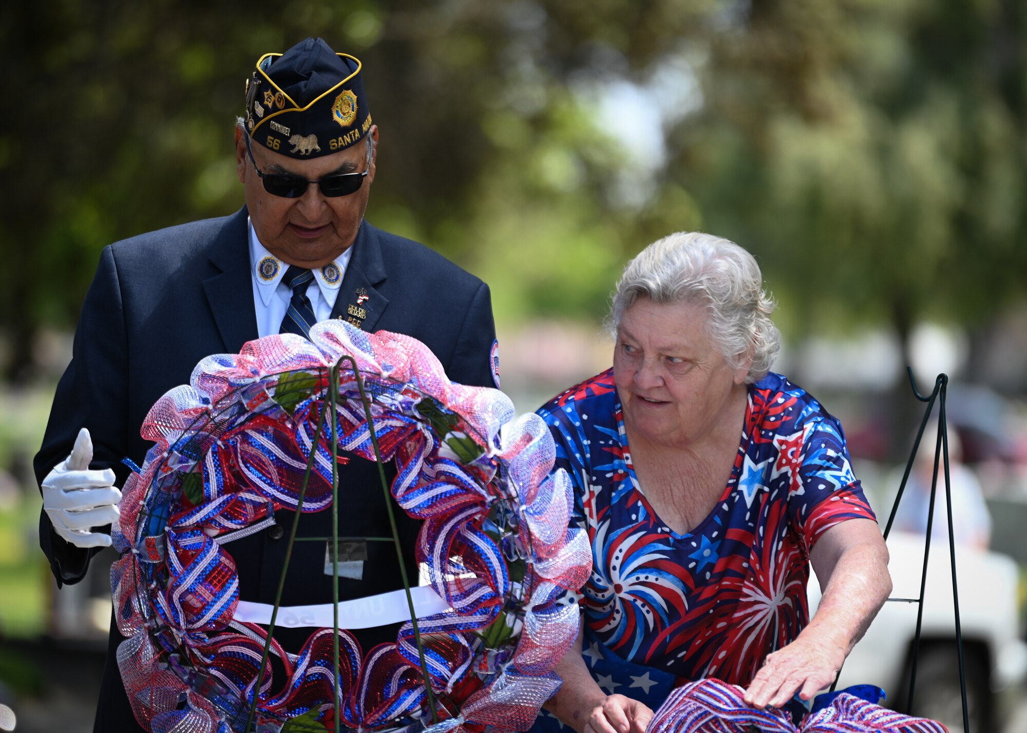 A man and a woman present a wreath.