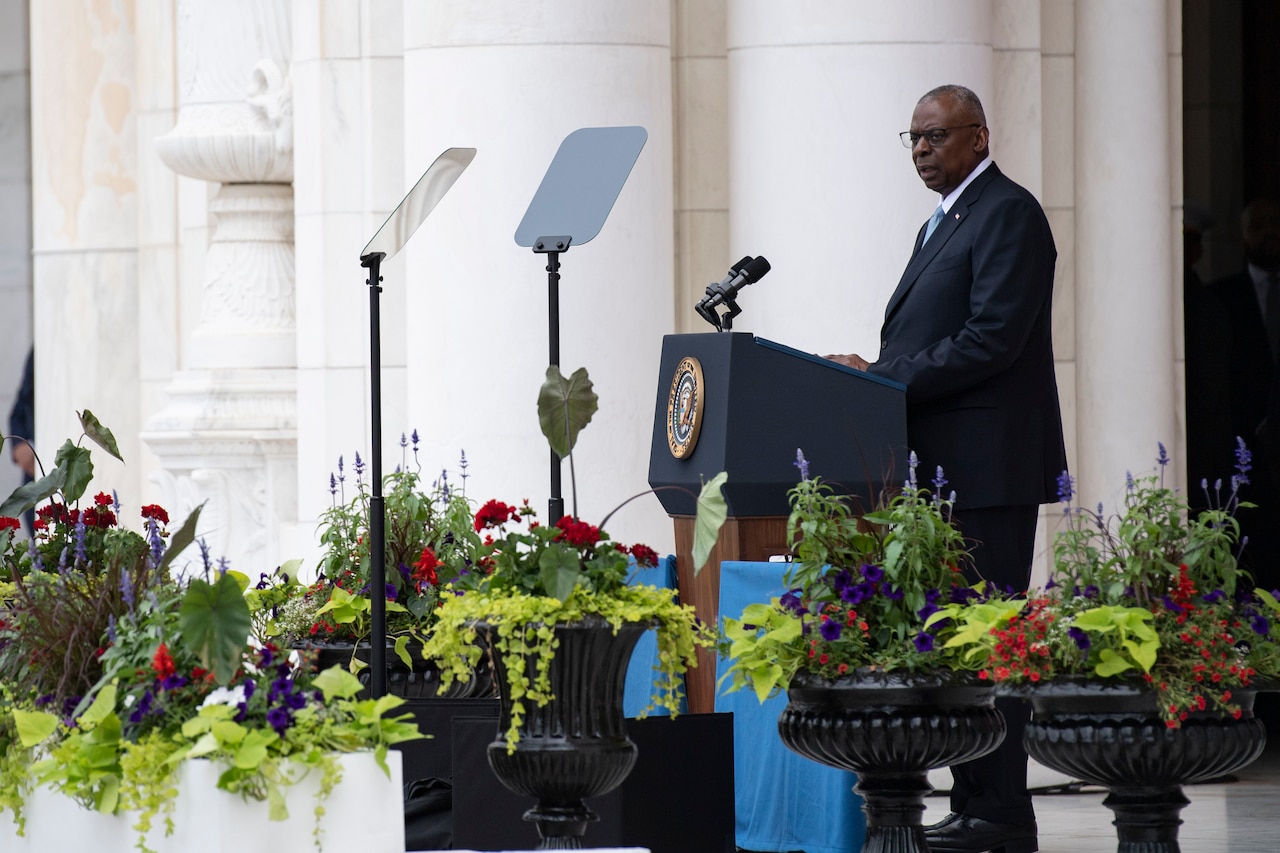 A civilian speaks from behind a podium.