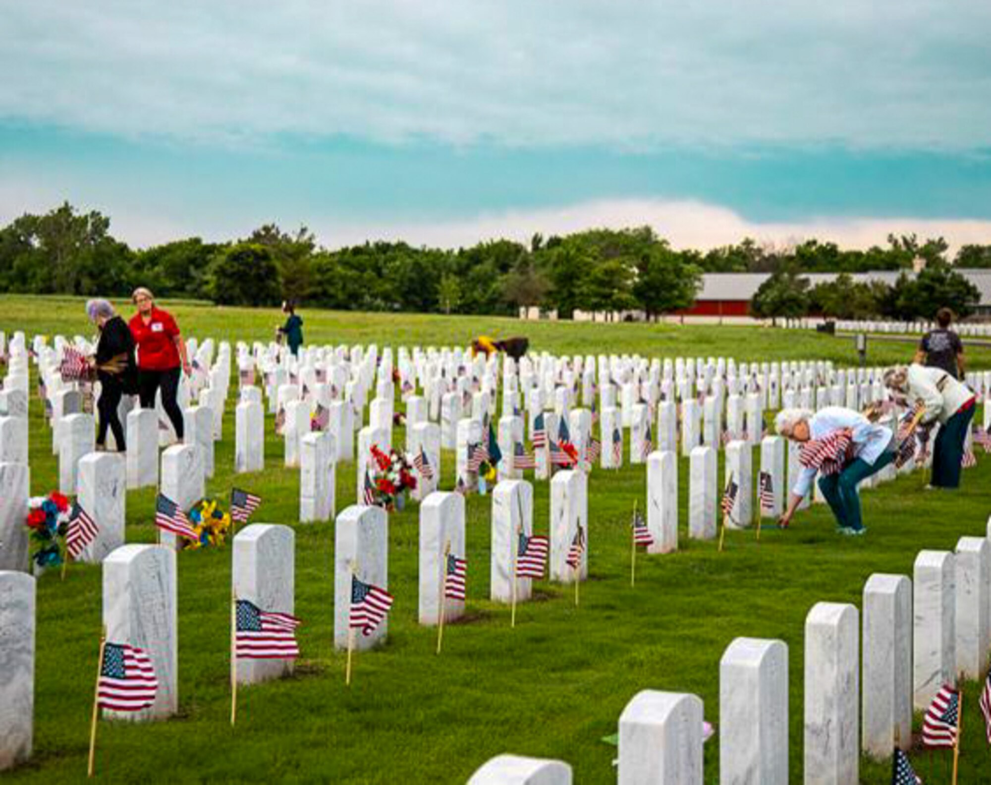 Dedicated volunteers honor fallen heroes by placing flags on headstones during Memorial Day 2021 at Fort Sill National Cemetery