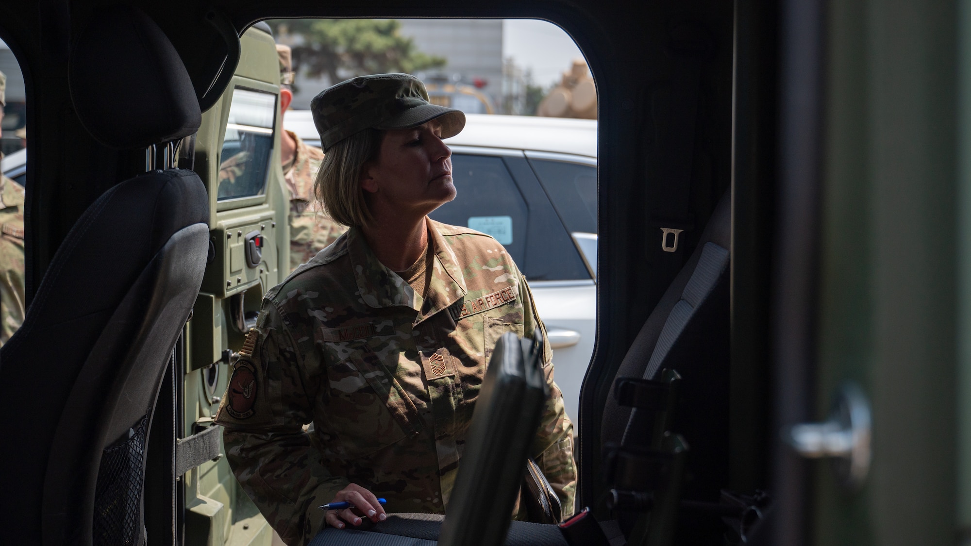 Chief Master Sgt. Kathleen McCool surveys the inside of an armored vehicle.