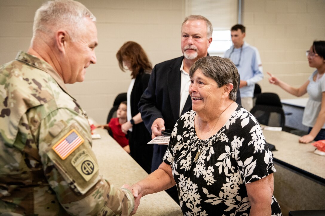 U.S. Army Maj. Gen. Haldane Lamberton, the adjutant general of the Kentucky National Guard, shakes hands with Ms. Frances Wilkins, widow of Chief Warrant Officer 5 Joe Wilkins at the Wilkins building renaming ceremony in his remembrance at the Wendell H. Ford Regional Training Center (WHFRTC) in Greenville, Kentucky on May 24, 2024. Wilkins was one of the three full-time employees who worked to make WHFRTC a major state training site.(U.S. Army National Guard photo by Andy Dickson)