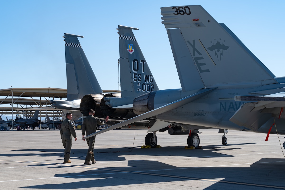 U.S. Air Force Col. Daniel Lehoski, commander of the 53rd Wing, walks alongside U.S. Navy Capt. Matthew Davin, Air Test and Evaluation Squadron Nine chief operational test director, on the Nellis Air Force Base, Nevada flightline on April 24, 2024. VX-9 along with several squadrons attached to the 53rd Wing met at Nellis AFB to participate in Black Flag 24-1; an Operational Test-focused exercise that evaluates the suitability of emerging capabilities and tactics in multi-domain, multi-service, operationally relevant scenarios. (U.S. Air Force photo by Airman 1st Class Brianna Vetro)
