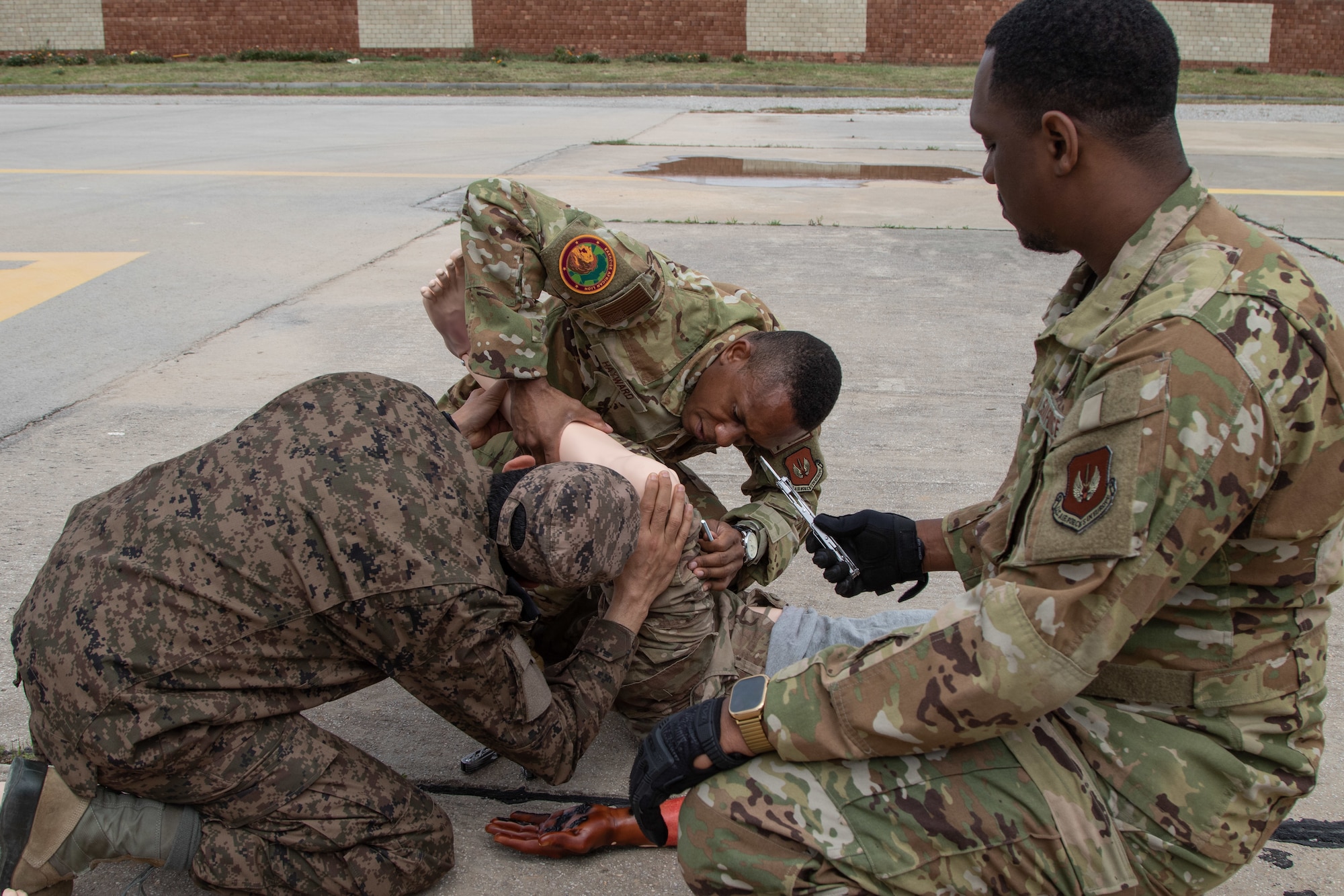 U.S. Air Force Staff Sgt. Devin Bruner, right, offers a tool to fellow Staff Sgt. Charles Hayward, both with the 86th Aeromedical Evacuation Squadron based in Ramstein, Germany, as they work with their Tunisian Armed Forces counterpart to prepare a simulated casualty during aeromedical evacuation training at exercise African Lion 2024 (AL24) in Tunis, Tunisia, May 2, 2024. AL24 marks the 20th anniversary of U.S. Africa Command’s premier joint exercise led by U.S. Army Southern European Task Force, Africa (SETAF-AF), running from April 19 to May 31 across Ghana, Morocco, Senegal and Tunisia, with over 8,100 participants from 27 nations and NATO contingents. (U.S. Army photo by Maj. Joe Legros)