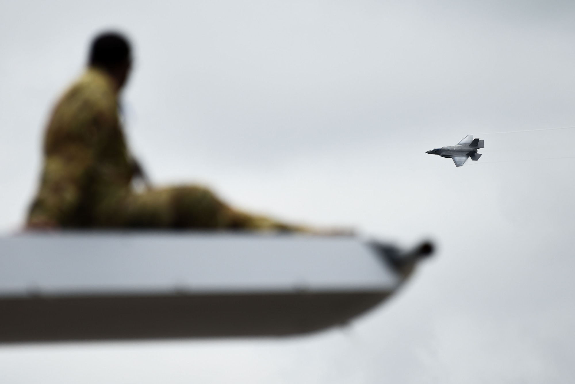 An Airman watches as the F-35A Lightning II Demonstration Team showcases their capabilities during the 2024 First State Airshow at Dover Air Force Base, Delaware, May 17, 2024. The First State Airshow was a free, two-day event, open to the public, which featured 23 static displays and 18 aerial performers. (U.S. Air Force photo by Staff Sgt. Deven Schultz)