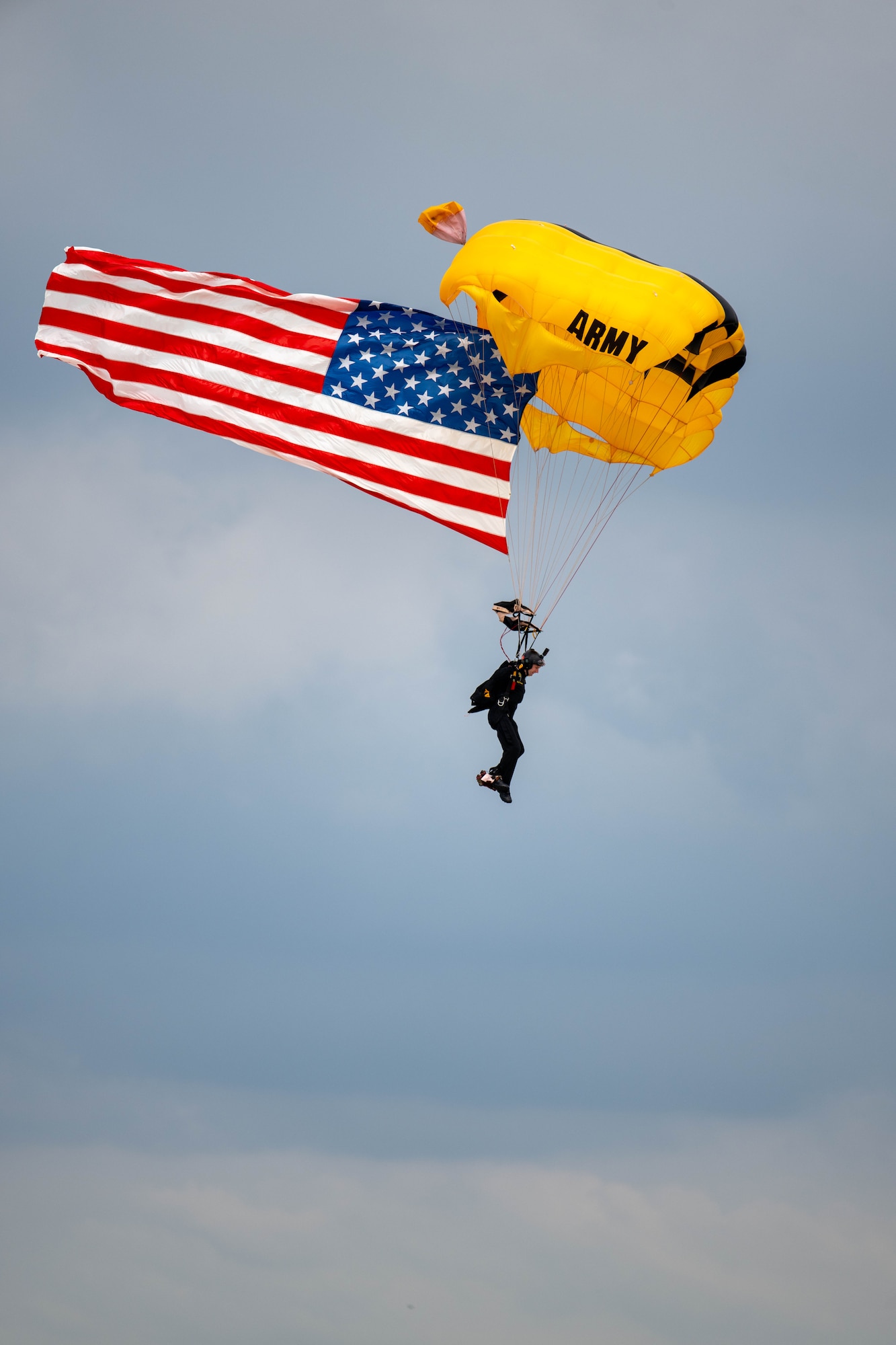 A member of the United States Army Parachute Team, The Golden Knights fly the United States Flag during a demonstration at Dover Air Force Base, Delaware, May 19, 2024. The First State Airshow was a free, two-day event open to the public that featured 23 static displays and 18 aerial performers. (U.S. Air Force photo by Mauricio Campino)