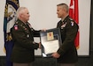 Maj. Gen. Hal Lamberton, Adjutant General-Kentucky, hands Col. Timothy Starke the Kentucky Distinguished Service Medal at his retirement ceremony at the Wellman Armory auditorium on Boone National Guard Center in Frankfort, Ky., May 8, 2024. (U.S. Army National Guard photo by Sgt. 1st Class Benjamin Crane