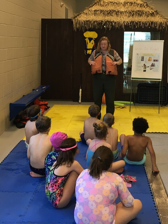 Park Ranger showing students how to put on a life jacket.