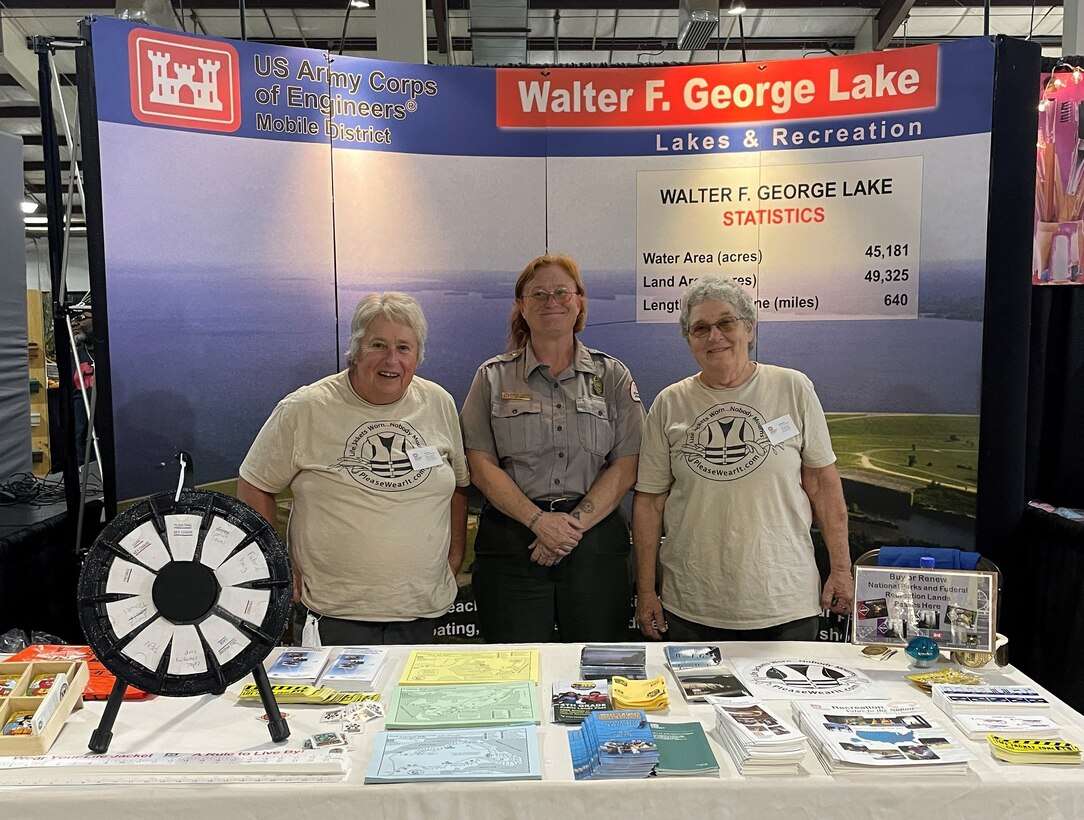 Three people standing in front of a booth.