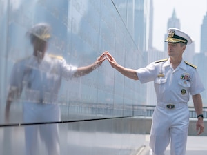 Vice Adm. Doug Perry touches names on the wall of the Empty Sky: 9/11 Memorial in Jersey City, N.J., during Fleet Week New York.