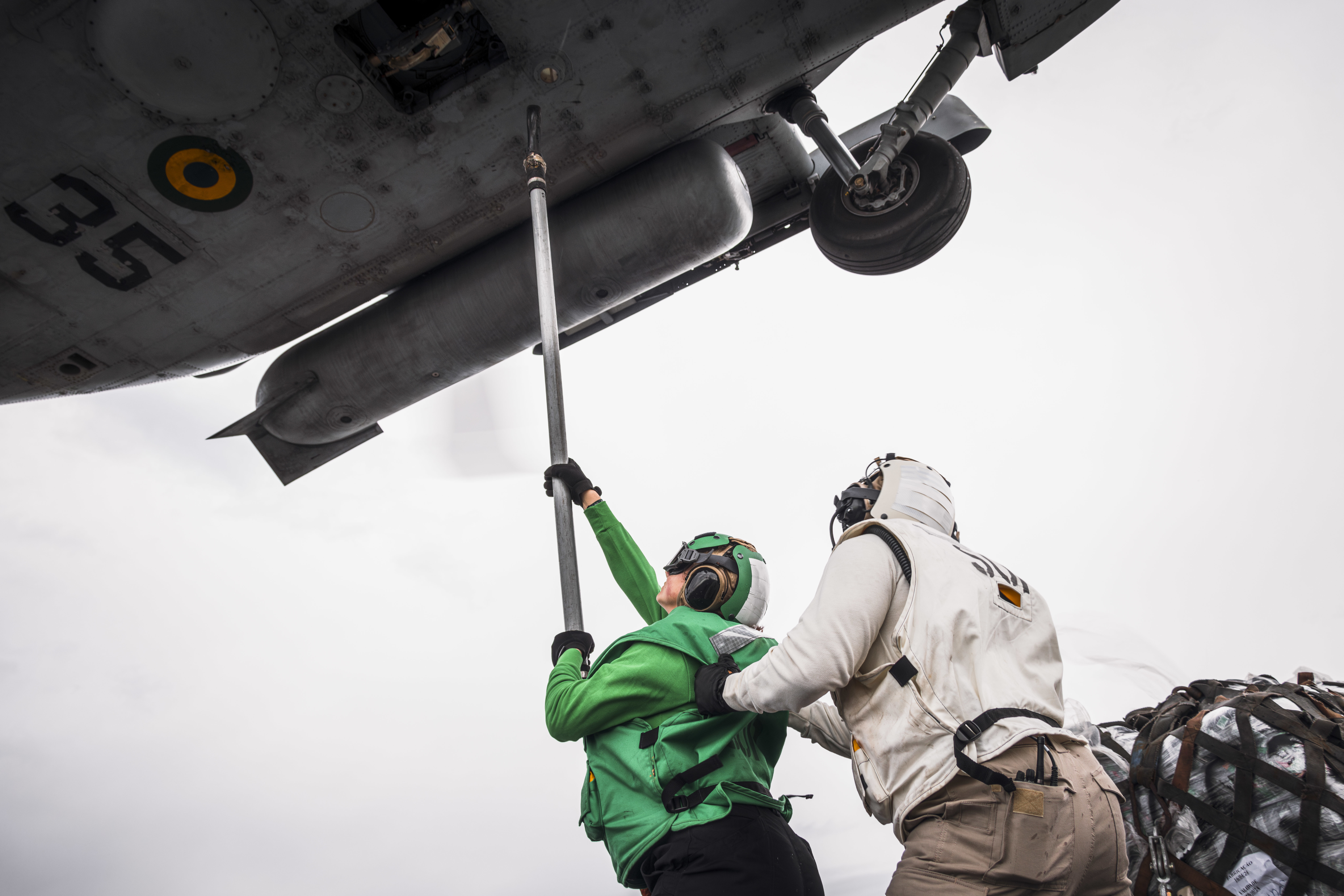 Sailors hook supplies onto a Brazilian navy helicopter aboard USS George Washington (CVN 73) during a vertical replenishment with the Brazilian navy.
