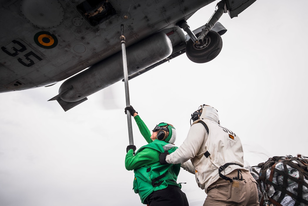 Sailors hook supplies onto a Brazilian navy helicopter aboard USS George Washington (CVN 73) during a vertical replenishment with the Brazilian navy.