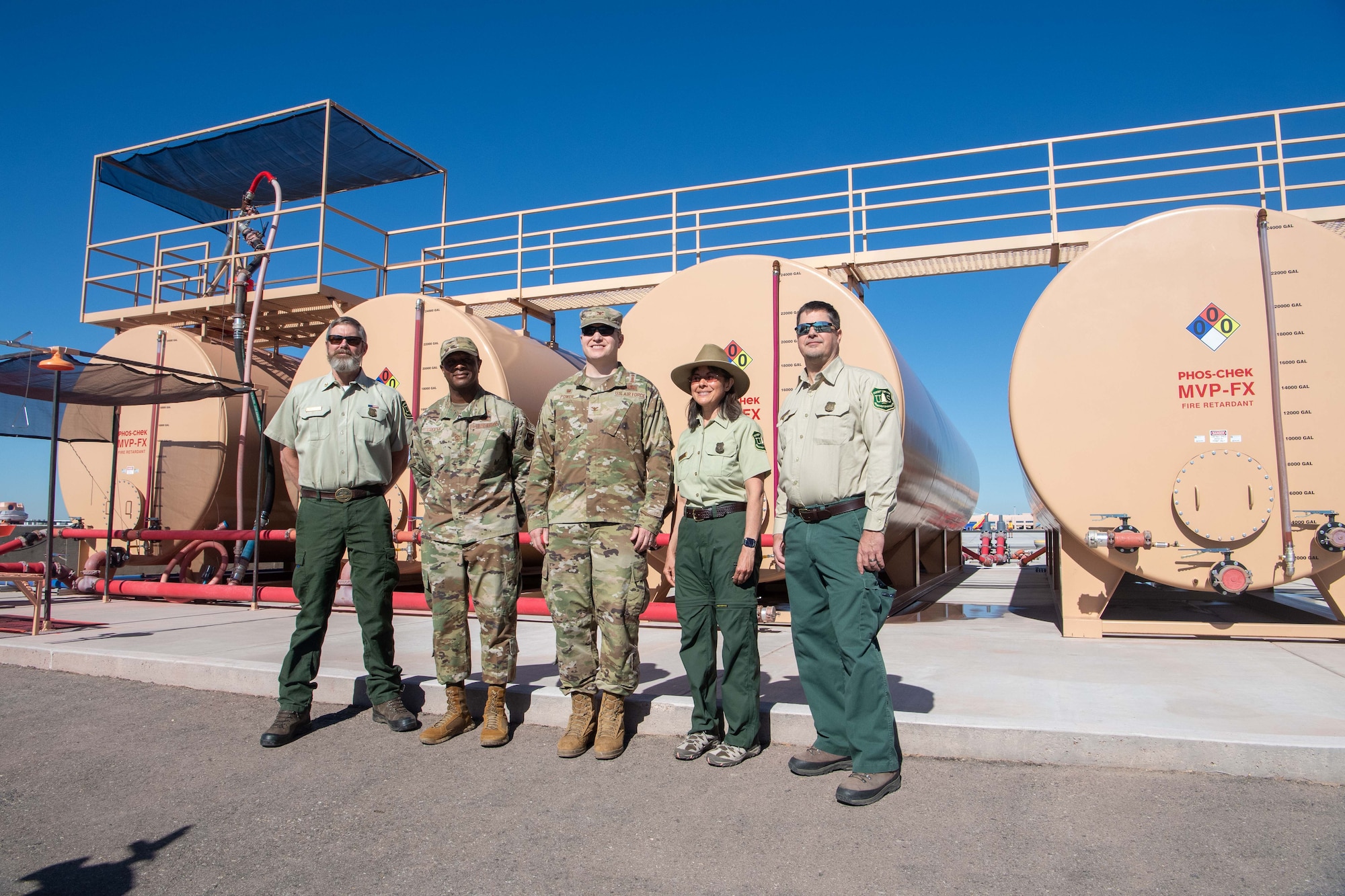 People pose by a tank.
