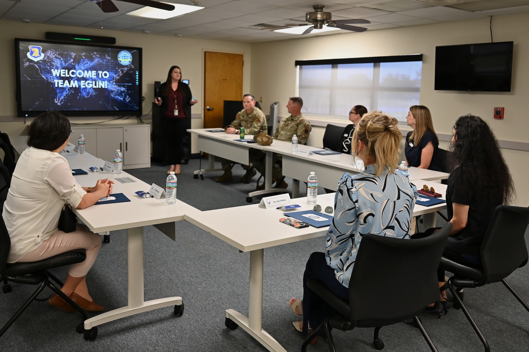 Cindy Wilsbach, wife  of U.S. Air Force Gen. Ken Wilsbach, commander of Air Combat Command, and Dr. Doniel Wolfe, spouse of CMSgt Wolfe, command chief of ACC, listen to a Military and Family Readiness briefing led by Megan Reagin, community readiness consultant, at Eglin Air Force Base, Florida, April 12, 2024. The Eglin M&FRC is the cornerstone of the Eglin family support system, helping Armed Forces personnel and their families enhance their readiness and quality of life. (U.S. Air Force photo by Capt. Lindsey Brewer)
