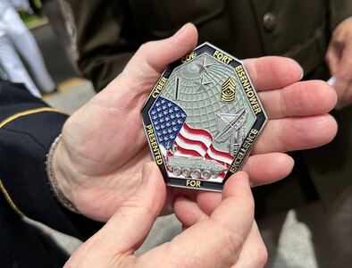 A veteran holds the Cyber Center of Excellence's unit coin after the Memorial Day ceremony in downtown Augusta, Ga.