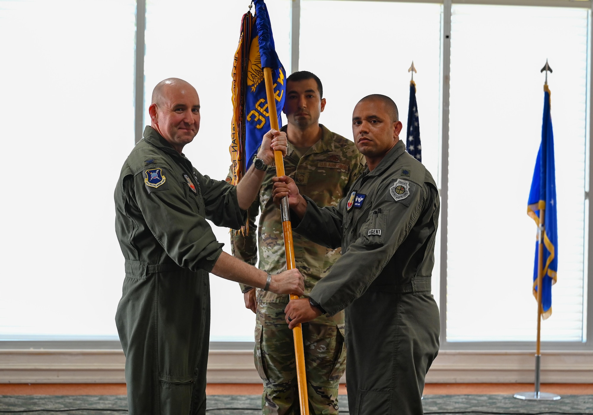 U.S. Air Force Col. Robert Cocke, 350th Spectrum Warfare Group commander, left, passes the guidon to U.S. Air Force Lt. Col. Dimitrius Ward, 36th Electronic Warfare Squadron commander, right, during the unit’s assumption of command at Eglin Air Force Base, Florida, May 23, 2024. The 36th EWS is comprised of six flights: pod maintenance, special missions, legacy systems, air dominance, cybersecurity and IT, and advanced systems. (U.S. Air Force photo by Capt. Benjamin Aronson)