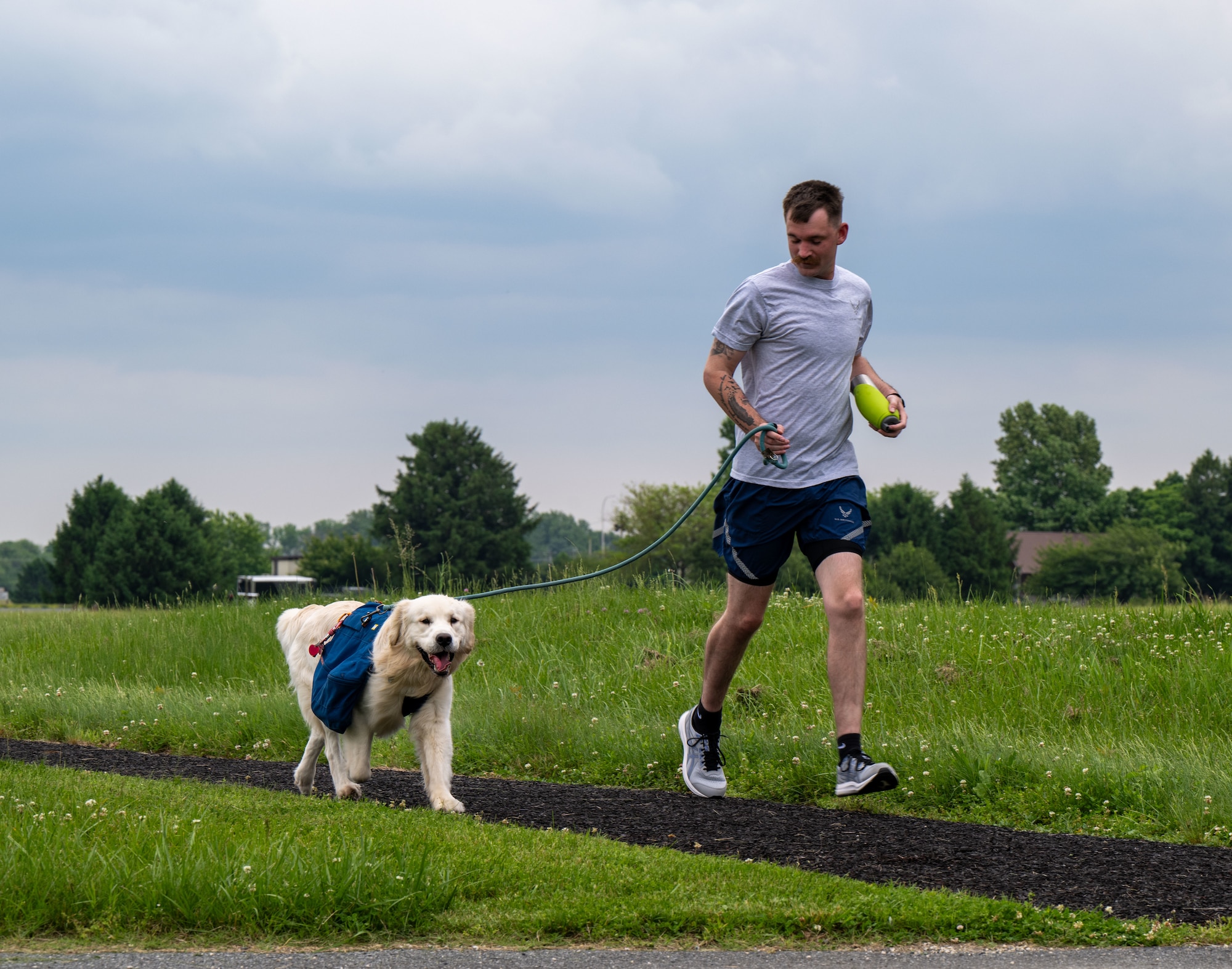An Airmen and his pet participate in the annual Port Dawg Memorial Run at Dover Air Force Base, Delaware, May 23, 2024. The 2.2-mile run is held each year in honor of fallen members from aerial ports across the country. (U.S. Air Force photo by Senior Airman Amanda Jett)