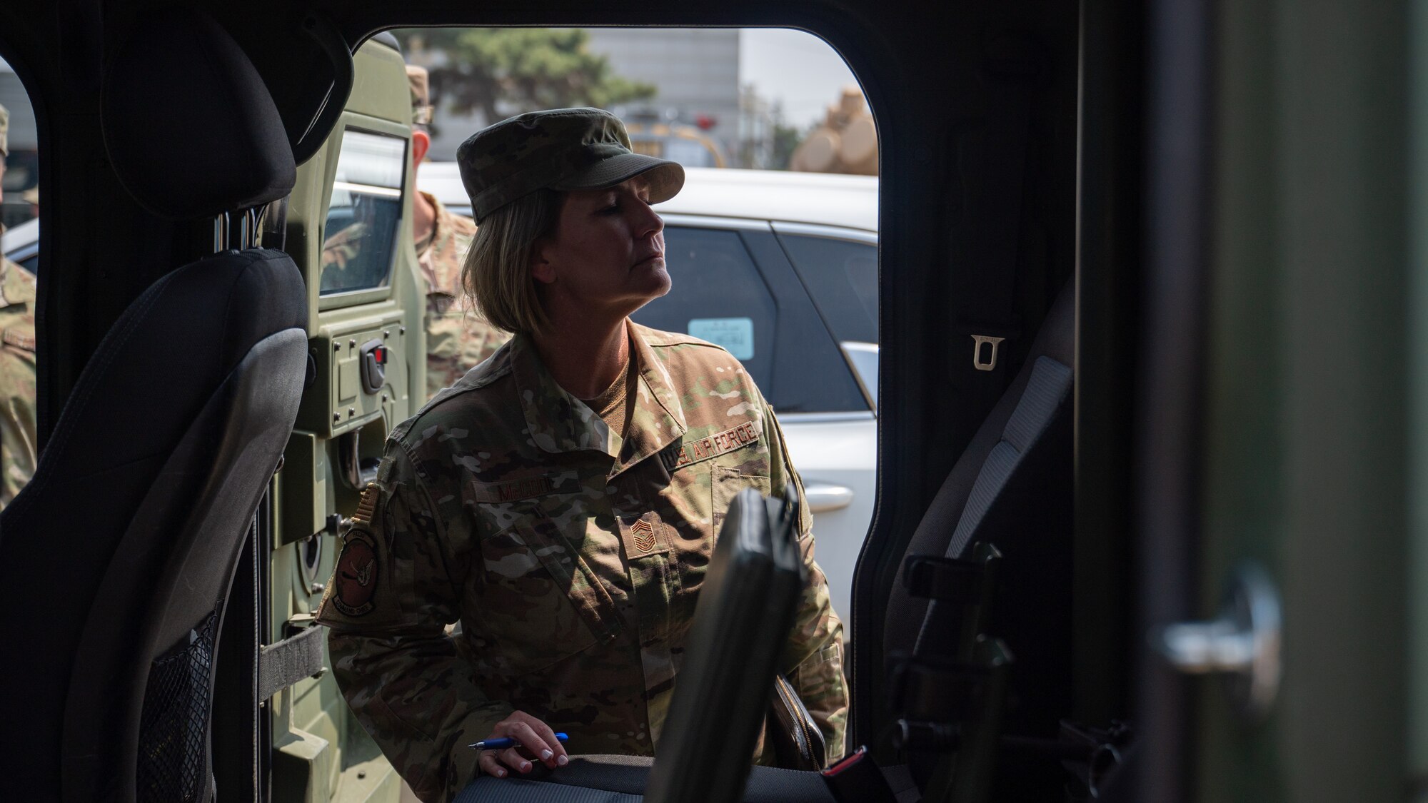 Chief Master Sgt. Kathleen McCool surveys the inside of an armored vehicle.