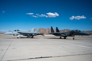 A U.S. Navy F/A-18 Super Hornet, assigned to the "Vampires" of Air Test and Evaluation Squadron Nine, is parked next to a U.S. Air Force F-15EX Eagle II, assigned to the 53rd Wing, during exercise Black Flag 24-1 at Nellis Air Force Base, Nevada, April 24, 2024. Black Flag is a two-week Operational Test-focused exercise that evaluates the suitability of emerging capabilities and tactics in multi-domain, multi-service, operationally relevant scenarios. (U.S. Air Force photo by Airman 1st Class Brianna Vetro)
