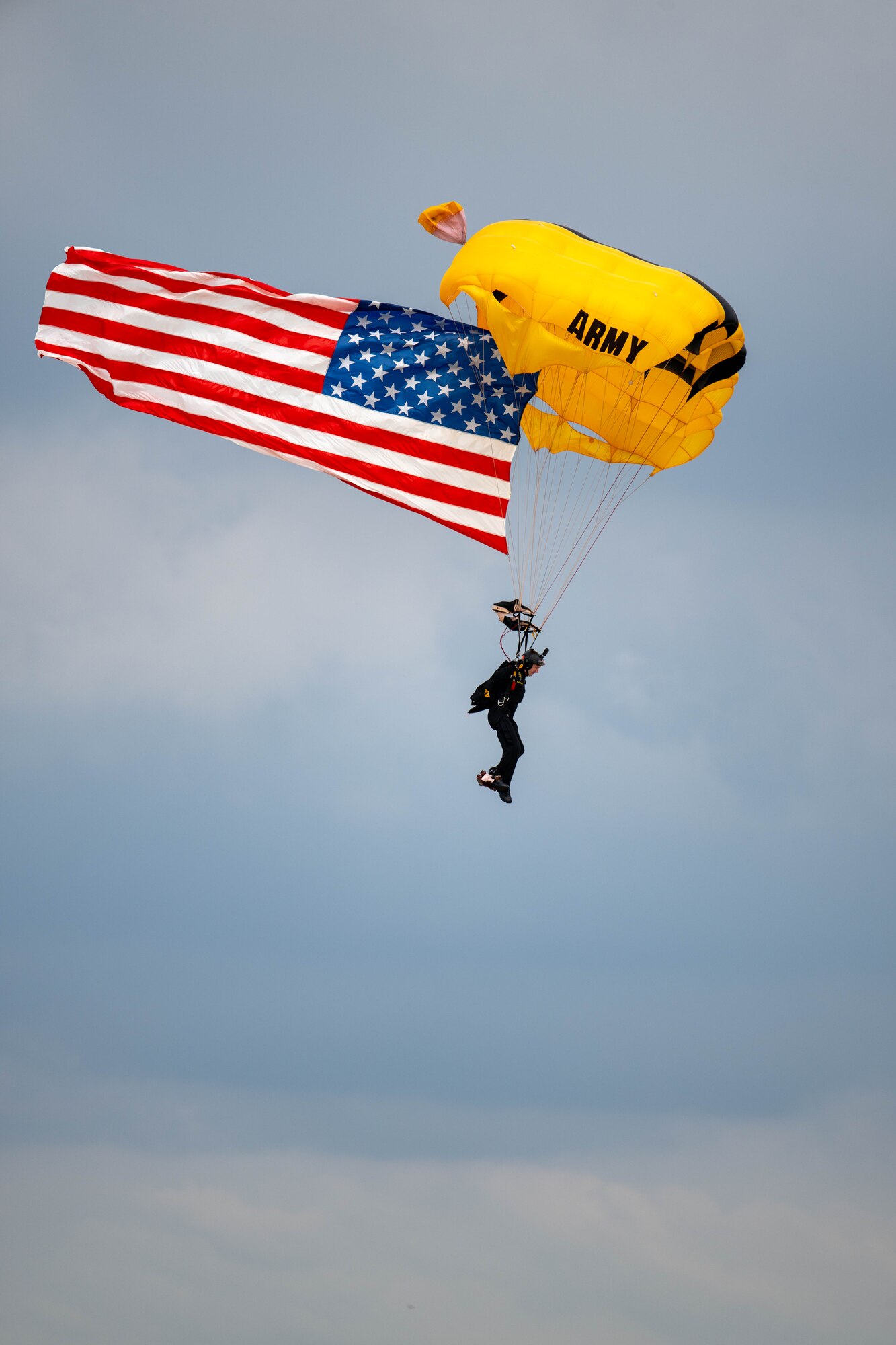 A member of the United States Army Parachute Team, The Golden Knights fly the United States Flag during a demonstration at Dover Air Force Base, Delaware, May 19, 2024. The First State Airshow was a free, two-day event open to the public that featured 23 static displays and 18 aerial performers. (U.S. Air Force photo by Mauricio Campino)