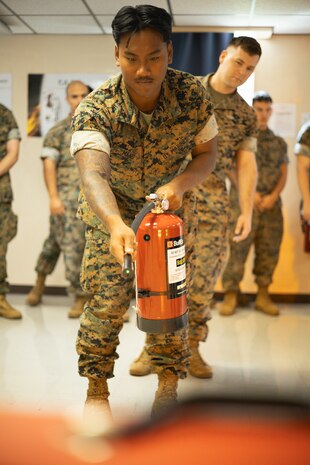 U.S. Marine Corps Lance Cpl. Bawi Mang, an automotive maintenance technician with 3rd Reconnaissance Battalion, 3rd Marine Division, practices firefighting techniques using an electronic fire extinguisher during fire warden training on Camp Foster, Okinawa, Japan, May 9, 2024. Hosted regularly by Marine Corps Installations Pacific Fire and Emergency Services, the fire warden program is designed to provide commands with in-house representatives capable of identifying safety deficiencies on a daily basis. Through their innovation and excellence in fire prevention inspections, community outreach, public education programs and more, MCIPAC F&ES was nominated and selected as the 2023 Department of Defense Fire Prevention Program of the Year. Mang is a native of Ohio. (U.S. Marine Corps photo by Sgt. Alex Fairchild)