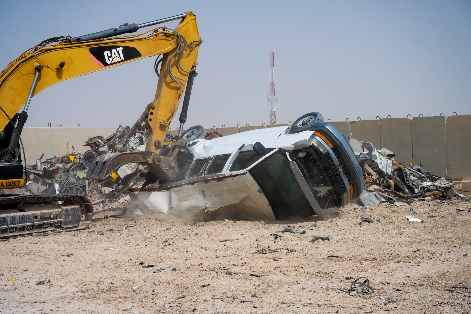 An excavator tears into a van during a Defense Logistics Agency familiarization tour at an undisclosed location in the U.S. Central Command area of responsibility, May 16, 2024. The van was marked for disposition and taken down for parts. DLA’s mission is to support the warfighter and to dispose of property in accordance with all applicable Department of Defense guidance and host nation laws. (U.S. Air Force photo)