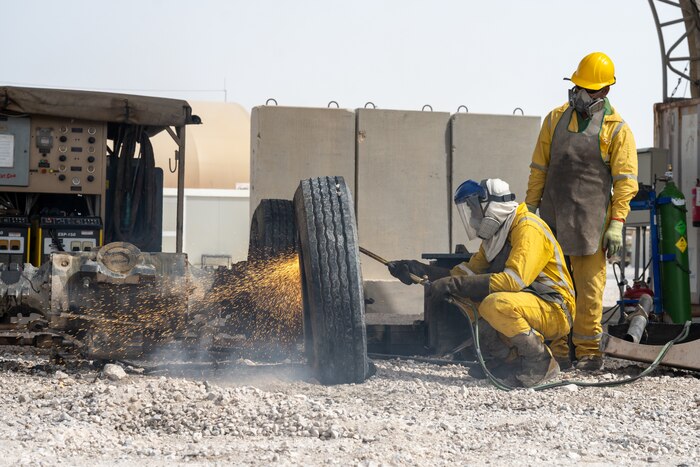 Defense Logistics Agency contractors take apart a wheel using an oxy-fuel cutting torch at an undisclosed location in the U.S. Central Command area of responsibility, May 16, 2024.