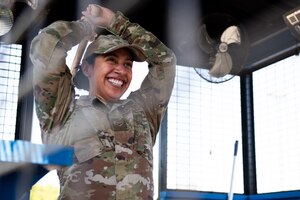 Airman smiles as she throws an axe