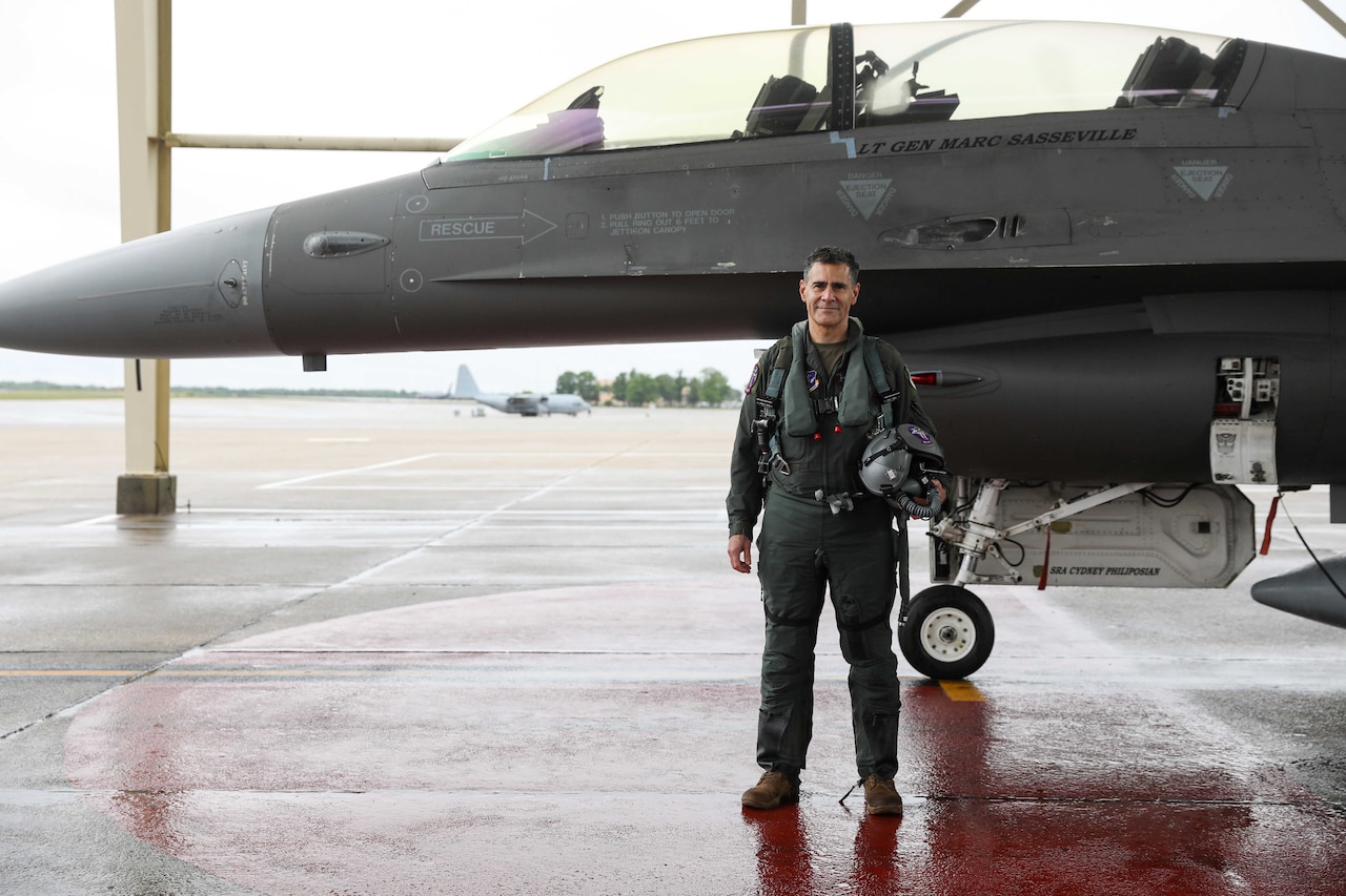 A pilot stands beside a jet.