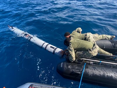 Sailors launch an unmanned underwater vehicle into the ocean