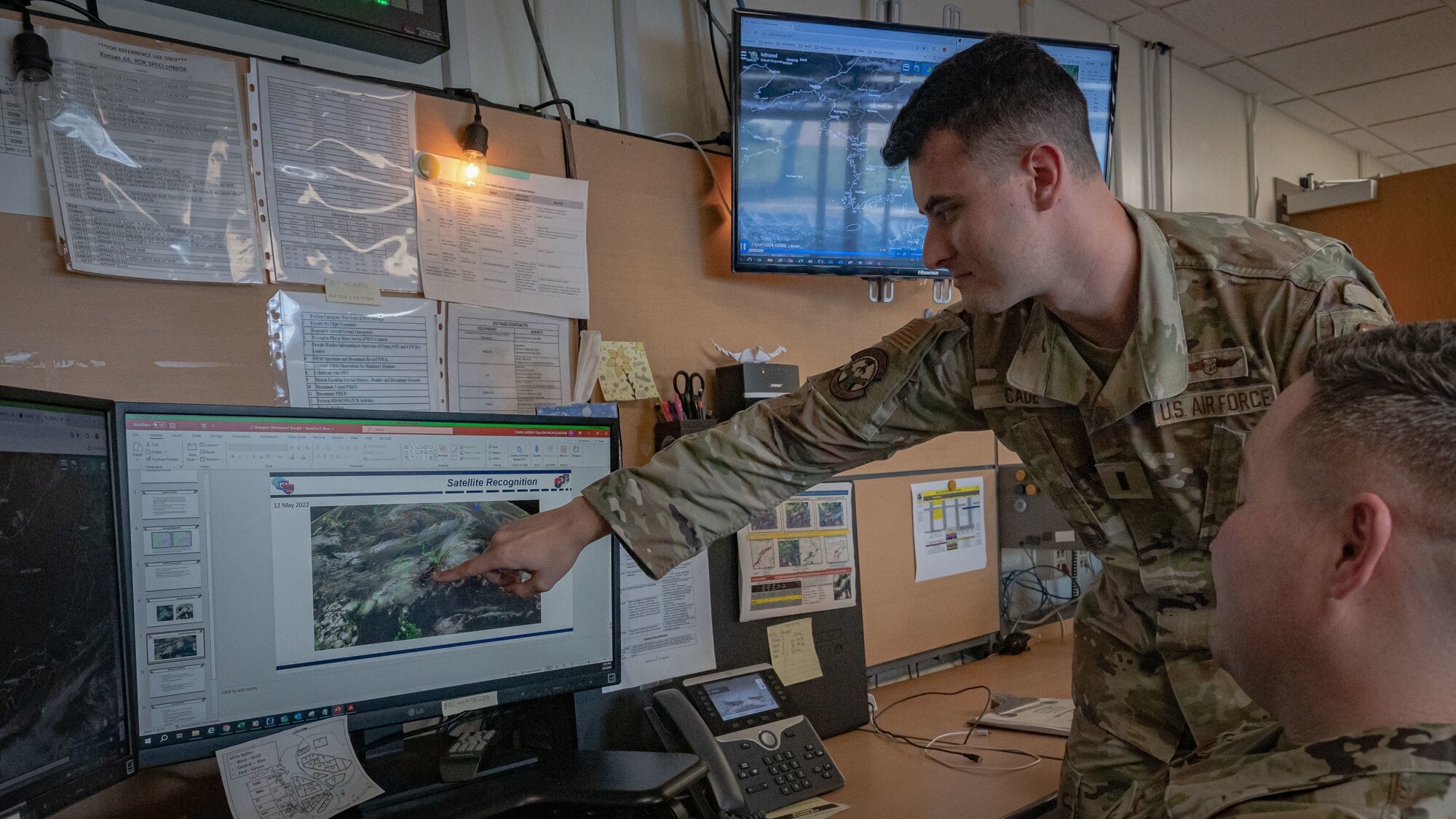1st Lt. Evan Cade, 8th Operations Support Squadron weather flight commander, left, and Tech. Sgt. Austin Young, 8th OSS non-commissioned officer in charge of airfield weather operations, review historical weather data.