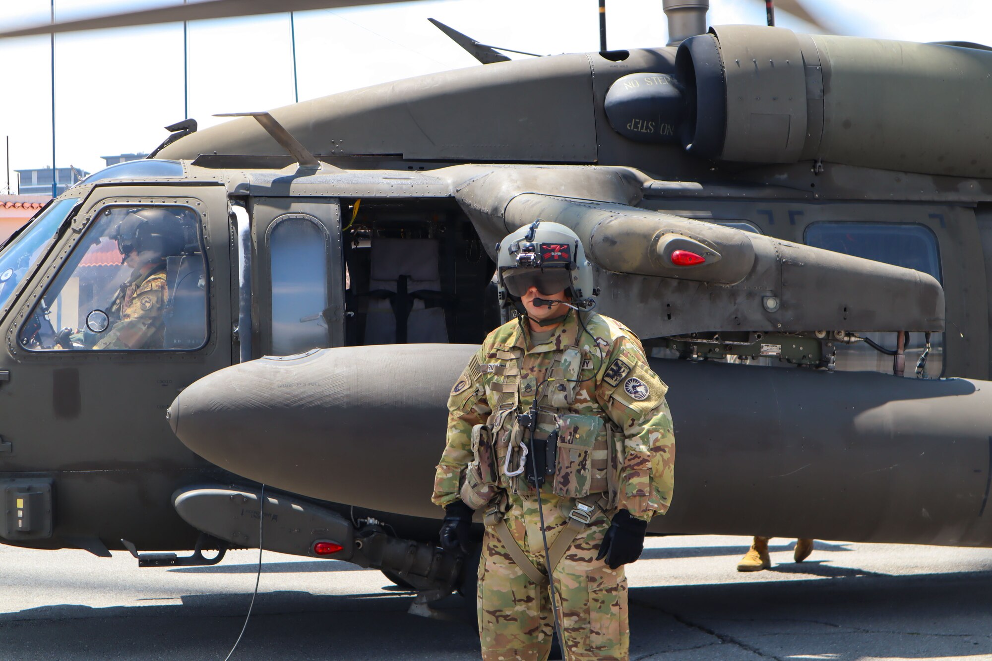 A photo of a soldier in front of a helicopter.