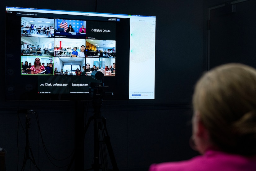 A person in civilian attire looks at a video conferencing screen.