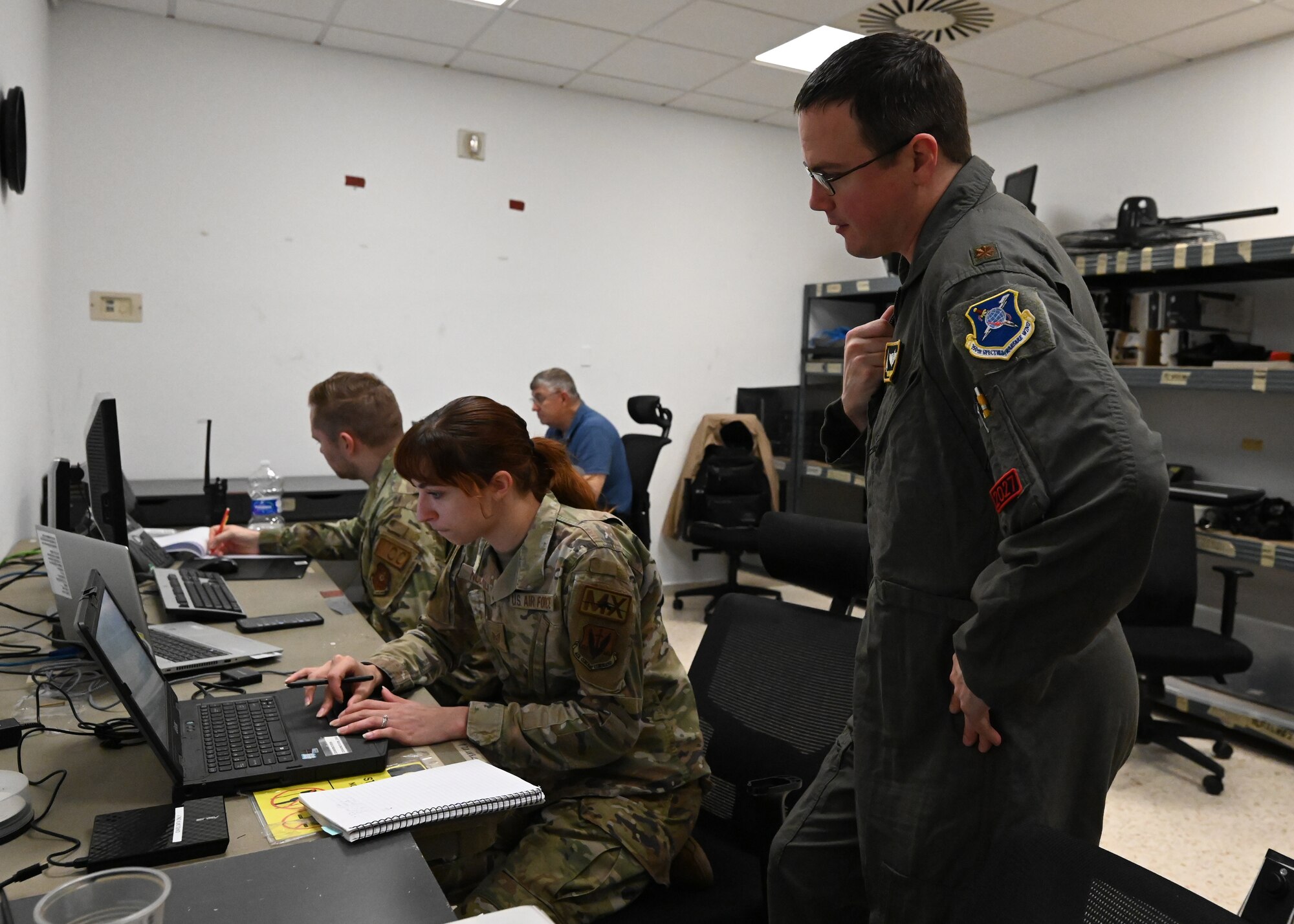 Staff Sgt. Chloe Nuckols, 16th Electronic Warfare Squadron mission data specialist, shows the deployable diagnostic system to Maj. Matthew Adams, 16th EWS assistant director of operations, at Morón Air Base, Spain, April 8, 2024. This is the first time the 16th EWS has supported a B-1B Lancer Bomber Task Force. The new partnership bridges the gap between B-1 engineers and aircrew by obtaining new data and mission flight information to supplement intelligence sources and complete rapid reprogramming for the electronic warfare system. (U.S. Air Force photo by Staff Sgt. Holly Cook)