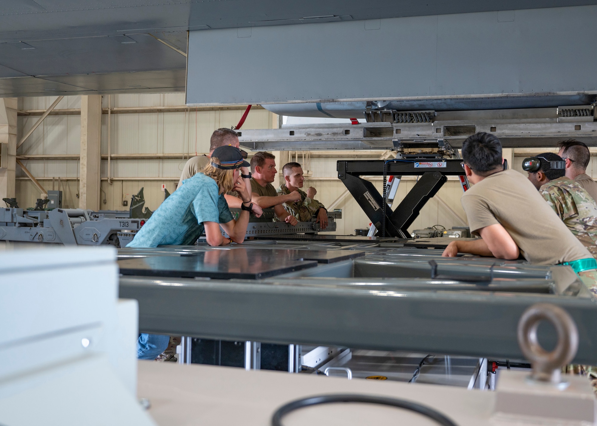 U.S. Airmen from the 7th Maintenance Group prepare to test the Munition Handling Unit - Tri-Spear X at Dyess Air Force Base, Texas, May 21, 2024. The MHU-TSX is the first trailer prototype that provides the required lift capability to safely load munitions onto a targeting pod pylon, reducing the logistical footprint required to get munitions from storage to point-of-use and loaded on the aircraft. (U.S. Air Force photo by Airman 1st Class Emma Anderson)