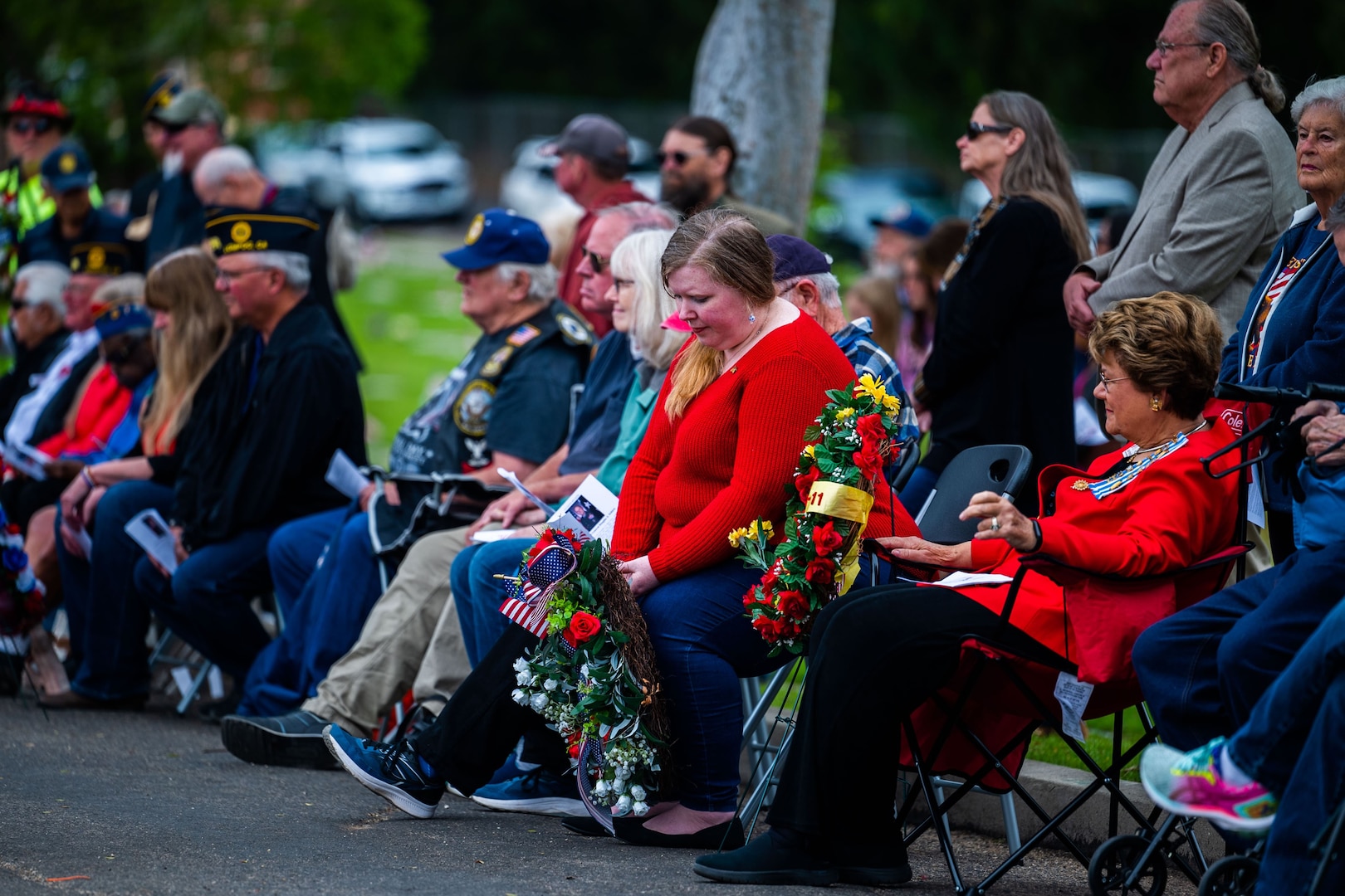 Ceremony participants and attendees sit alongside the road the Lompoc Cemetery during a Memorial Day ceremony.