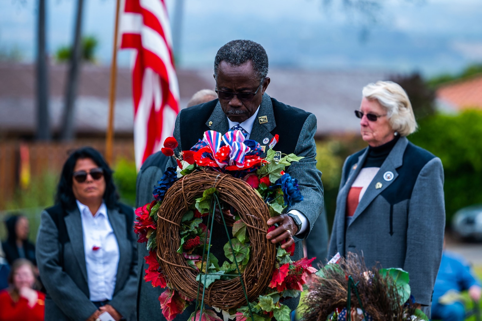 A man lays a wreath down during a Memorial Day ceremony at a cemetery.