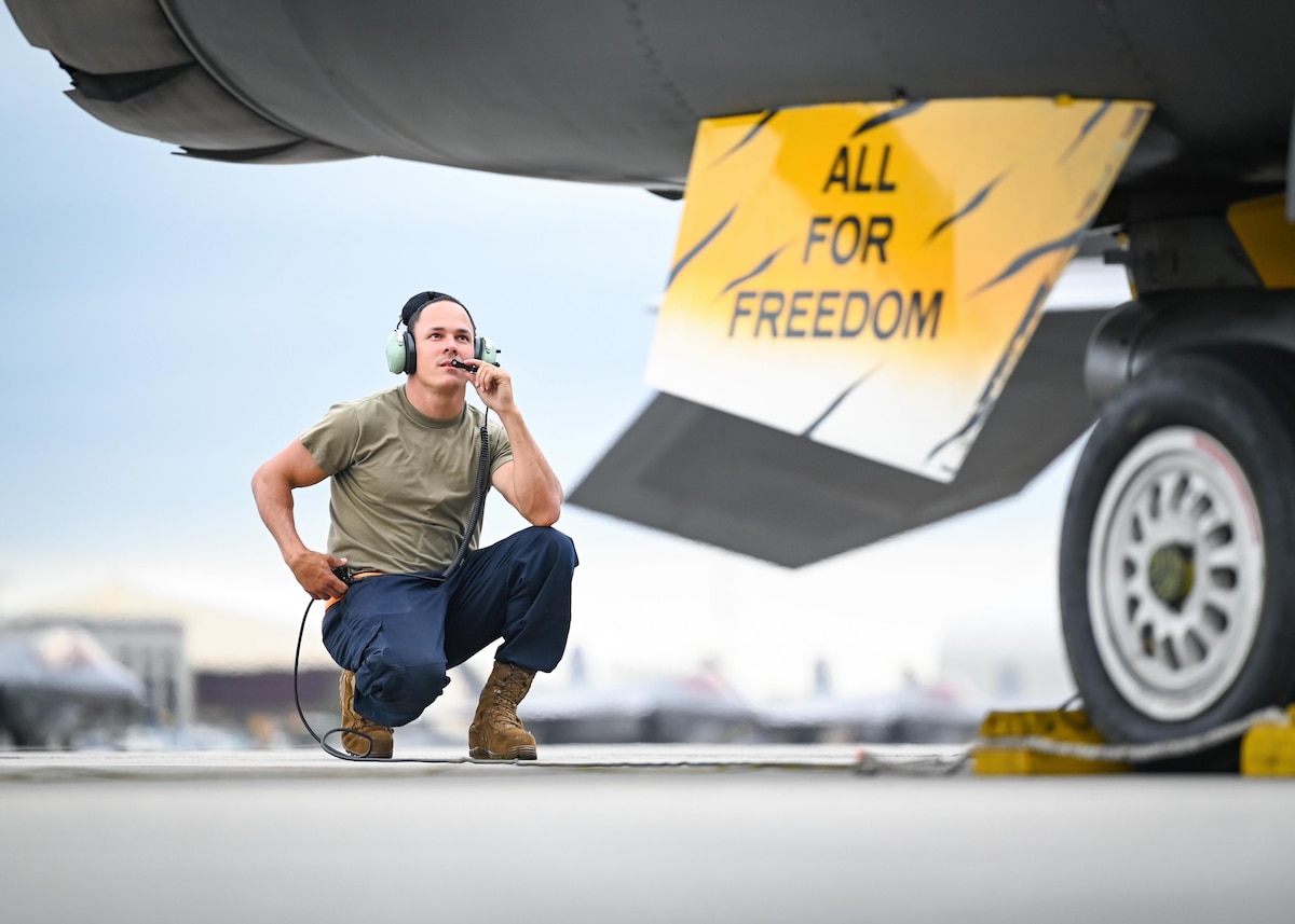 A crew chief performs pre-flight checks