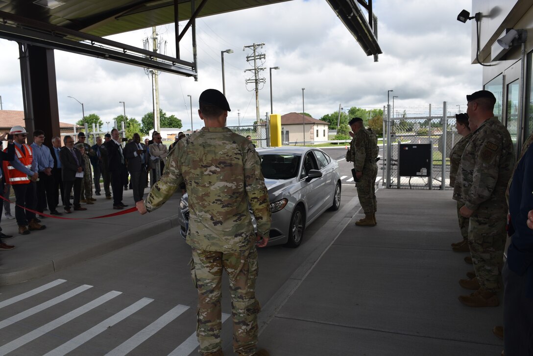 Maj. Brian Rhoney, 914th Security Forces Squadron commander, checks credentials and admits the first vehicle through the reopened Main Gate.