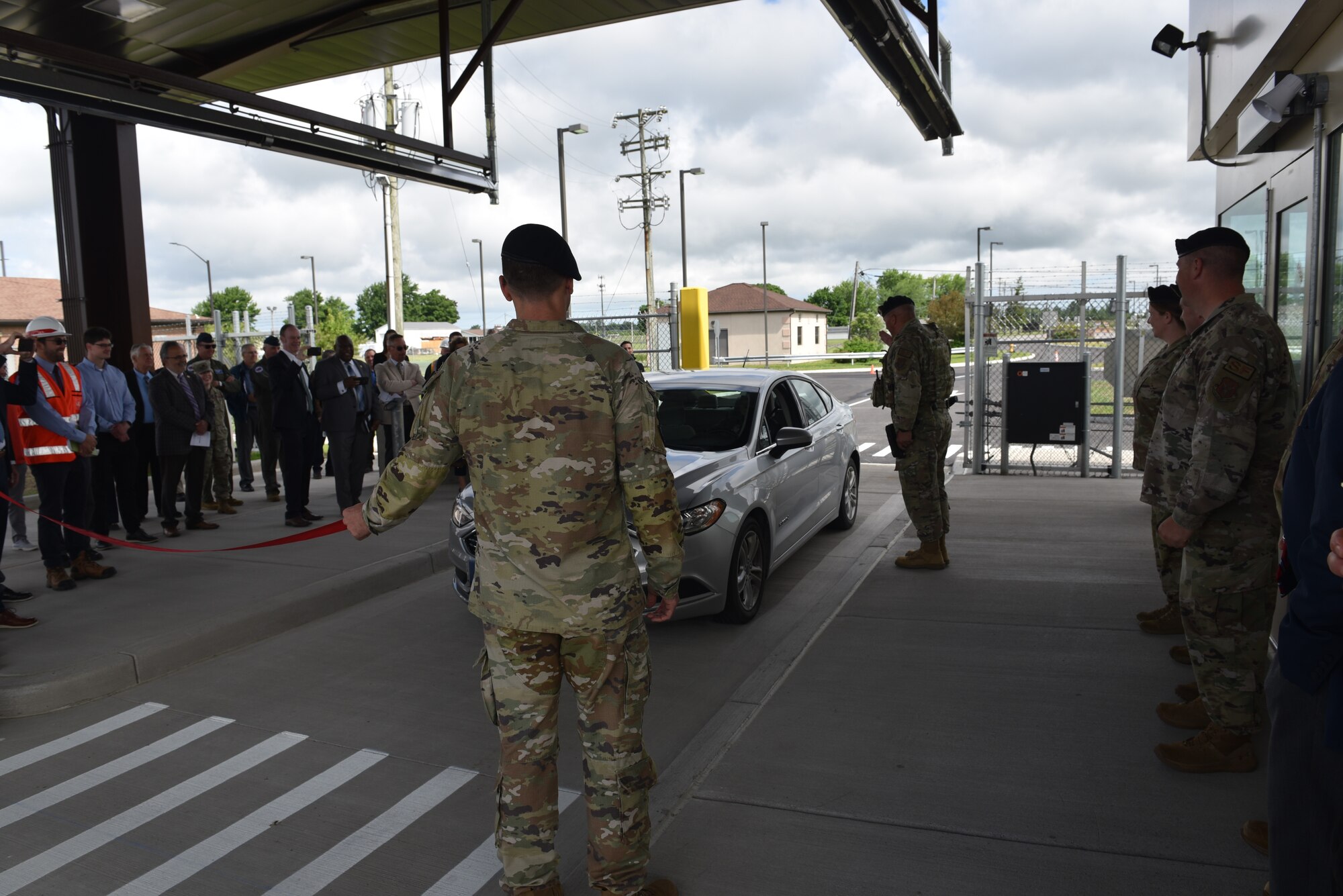 Maj. Brian Rhoney, 914th Security Forces Squadron commander, checks credentials and admits the first vehicle through the reopened Main Gate.