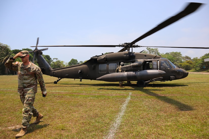 A soldier stepping off a helicopter.