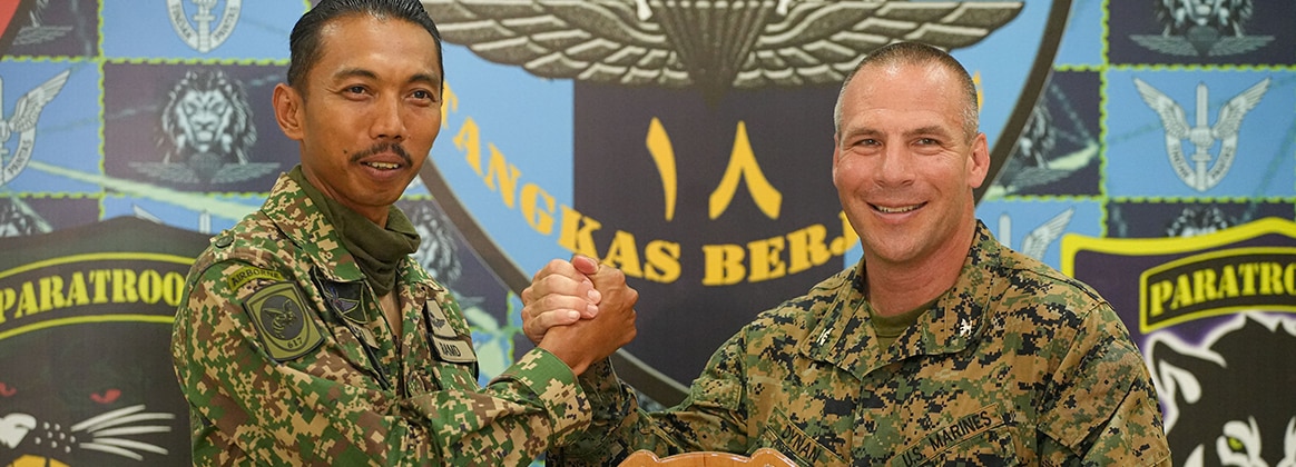 240528-M-EV477-1294 KUALA TERENGGANU, Malaysia (May 28, 2024) U.S. Marine Corps Col. Sean Dynan, commanding officer of the 15th Marine Expeditionary Unit gives a gift to Malaysia Army Lt. Col. Salmu Azhari, commanding officer of 9th Battalion, Royal Malay Regiment, 10th Brigade (Para), during a key leader engagement at Sri Pantai Camp, Kuala Terengganu, Malaysia, May 28, 2024. Tiger Strike is a bilateral exercise between U.S. and Malaysia armed forces designed to enhance communication and build combat readiness through combined amphibious operations and subject matter expert exchanges in support of a shared vision for security and stability in the region. (U.S. Marine Corps photo by 1st Lt. Robert Nanna)