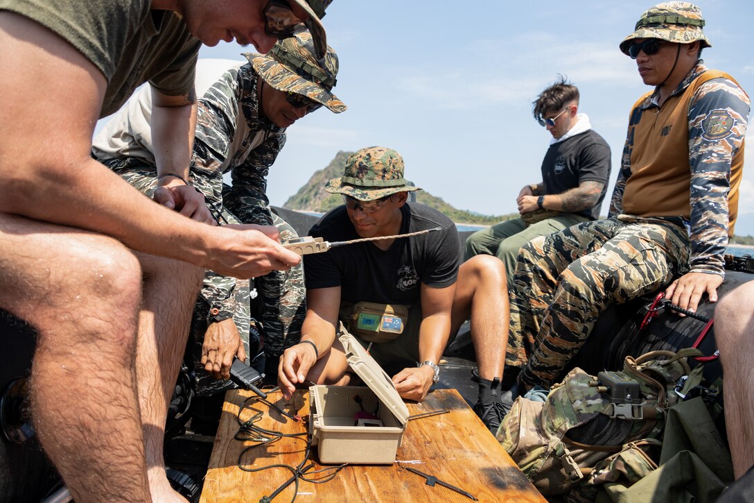 Explosive ordnance disposal technicians with the Philippine Marine Corps, Philippine Navy Special Operations Command, and U.S. Marine Corps prepare a transmitter atop a “Floating Freddy” for remote firing of demolition during underwater unexploded ordnance disposal demolitions off the coast of Caballo Island, Philippines during Archipelagic Coastal Defense Continuum May 14, 2024. ACDC is a series of bilateral exchanges and training opportunities between U.S. Marines and Philippine Marines aimed at bolstering the Philippine Marine Corps’ Coastal Defense strategy while supporting the modernization efforts of the Armed Forces of the Philippines. This event marked the first time in U.S. Marine Corps EOD history that dive and demolition training on live underwater ordnance was conducted outside the continental United States. (U.S. Marine Corps photo by Staff Sgt. Dana Beesley)