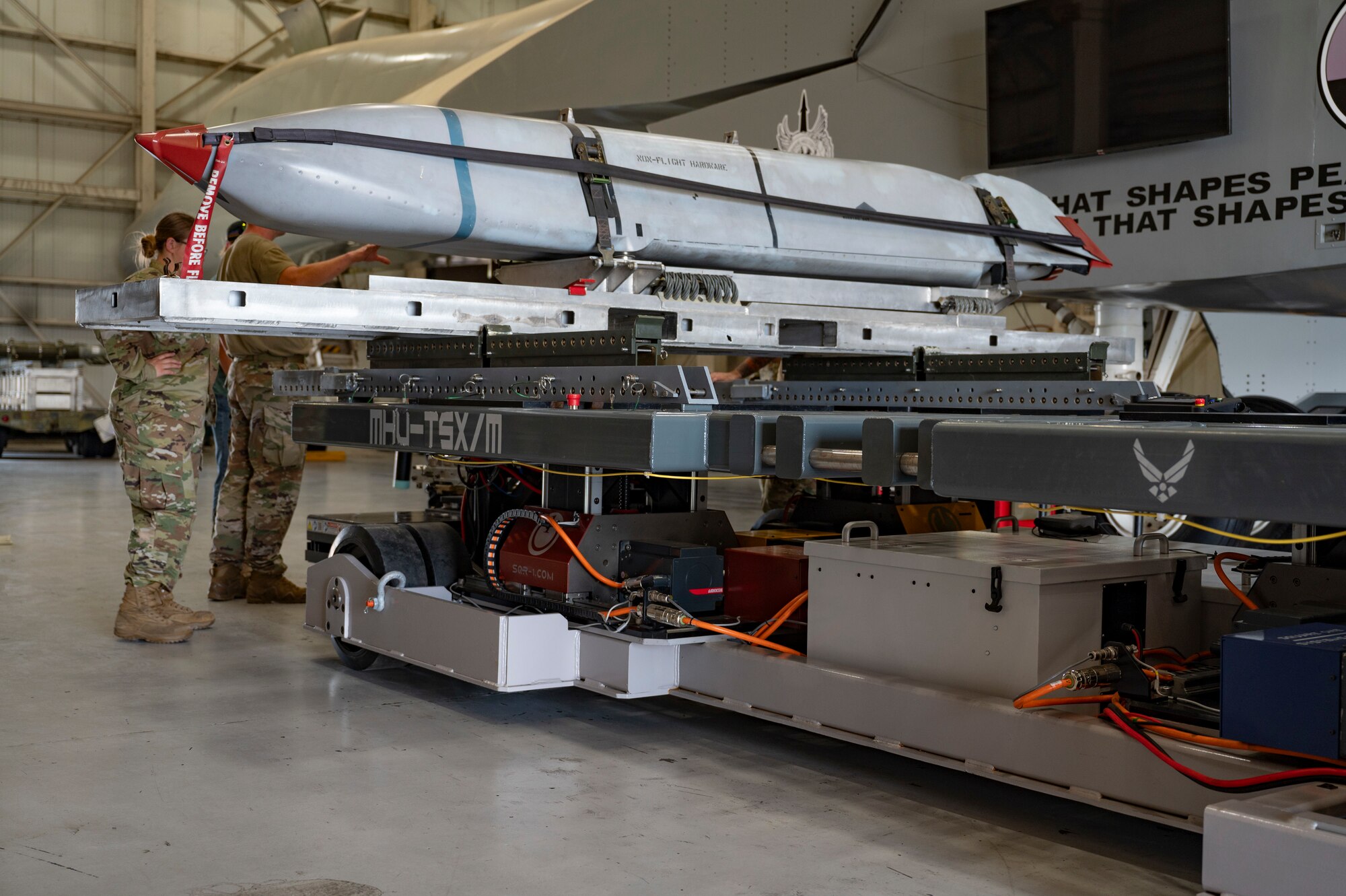 A munition is loaded onto a Munition Handling Unit - Tri-Spear X at Dyess Air Force Base, Texas, May 21, 2024. The introduction of the MHU-TSX reduces the need for a transportation truck and a lift truck due to its strength for transporting heavy munitions and its tilt capabilities to interface munitions into a canted rack properly. (U.S. Air Force photo by Airman 1st Class Emma Anderson)