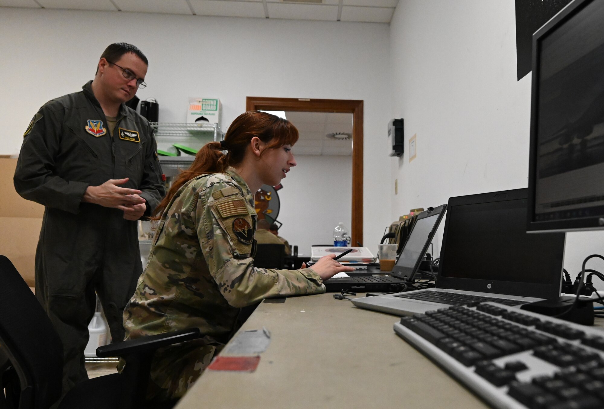 Staff Sgt. Chloe Nuckols, 16th Electronic Warfare Squadron mission data specialist, shows the deployable diagnostic system to Maj. Matthew Adams, 16th EWS assistant director of operations, at Morón Air Base, Spain, April 8, 2024. The 16th EWS brought their mission to develop, test, validate and field electromagnetic warfare capabilities for the warfighter to the B-1B Lancer Bomber Task Force for the first time. This new capability strengthens the BTF mission by creating rapid reprogramming for the B-1 electronic warfare system. (U.S. Air Force photo by Staff Sgt. Holly Cook)