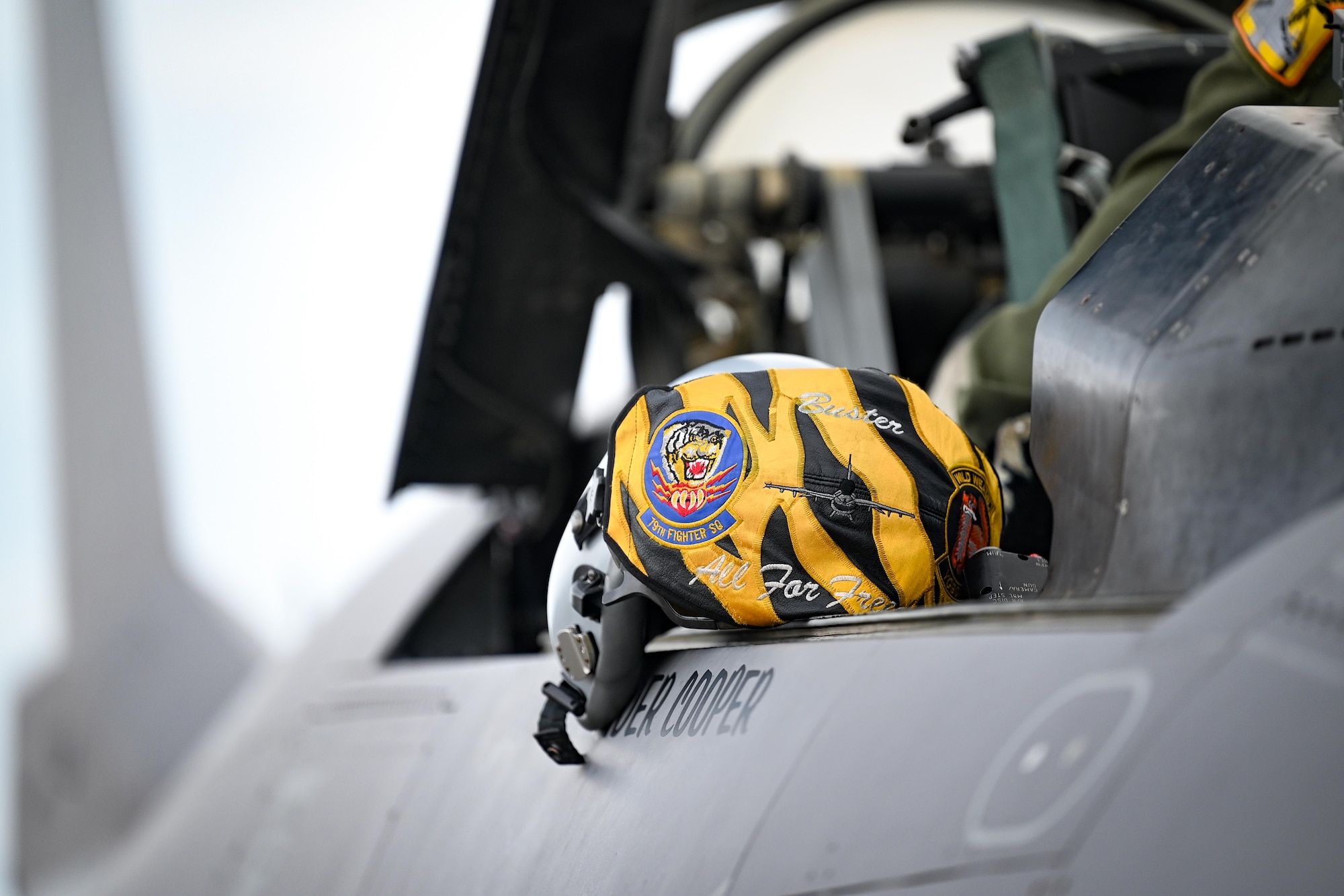 A pilot's helmet rests on the side of an aircraft.