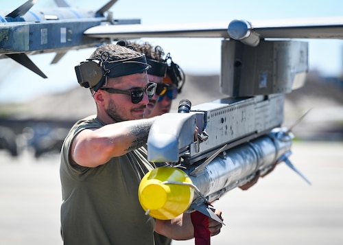 Weapons troops mount munitions onto an aircraft