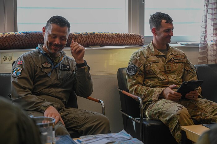 Royal Norwegian Air Force Maj. Pål-Christian Grosvold, 335th Squadron pilot, laughs with U.S. Air Force Capt. Scott Sivard, 61st Airlift Squadron pilot, at Station Group Gardermoen, Norway, May 13, 2024. Training with joint service members, and Allies and partners increases lethality and enhances interoperability, allowing forces to counter military aggression and coercion by sharing responsibilities for common defense.