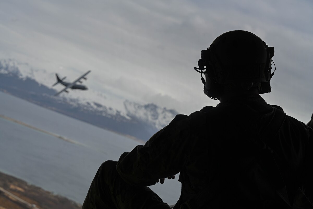 A U.S. Air Force member assigned to the 61st Airlift Squadron watches a C-130J Super Hercules fly over mountains in Norway, May 10, 2024. The C-130J Super Hercules serves as a cornerstone of strategic collaboration among Allied nations. Joint training exercises, logistical support missions, and cross-border operations help to foster a robust network of defense cooperation, enhancing our collective ability to respond swiftly and effectively to emerging challenges.